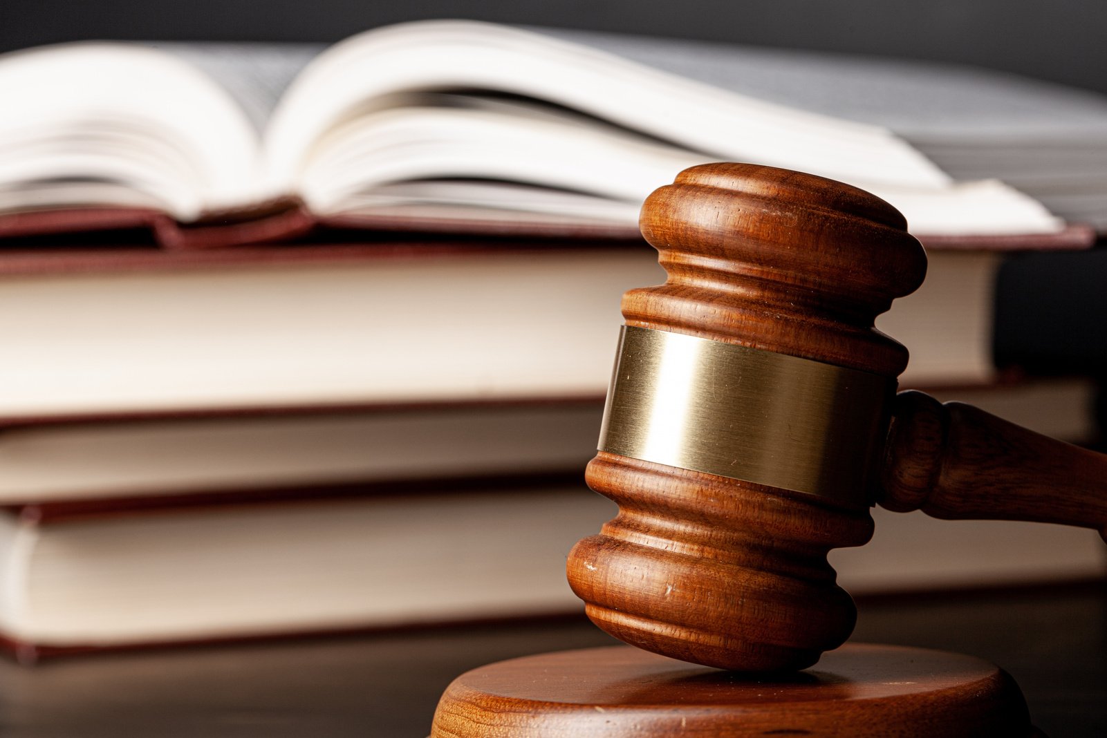 Wooden gavel and juridical books close up